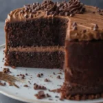 Délicieux gâteau courgette au chocolat à étages, nappé d'un glaçage riche et parsemé de pépites de chocolat. Une part a été coupée, révélant la texture moelleuse et les saveurs chocolatées de ce dessert surprenant.